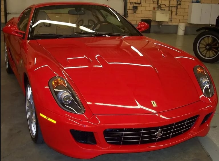 Bright red sports car on display in a garage with sleek design and chrome wheels